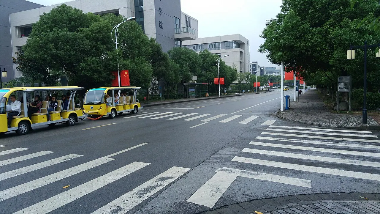 Hai xe nhỏ màu vàng trên con đường trong khuôn viên Đại học Giang Nam.
