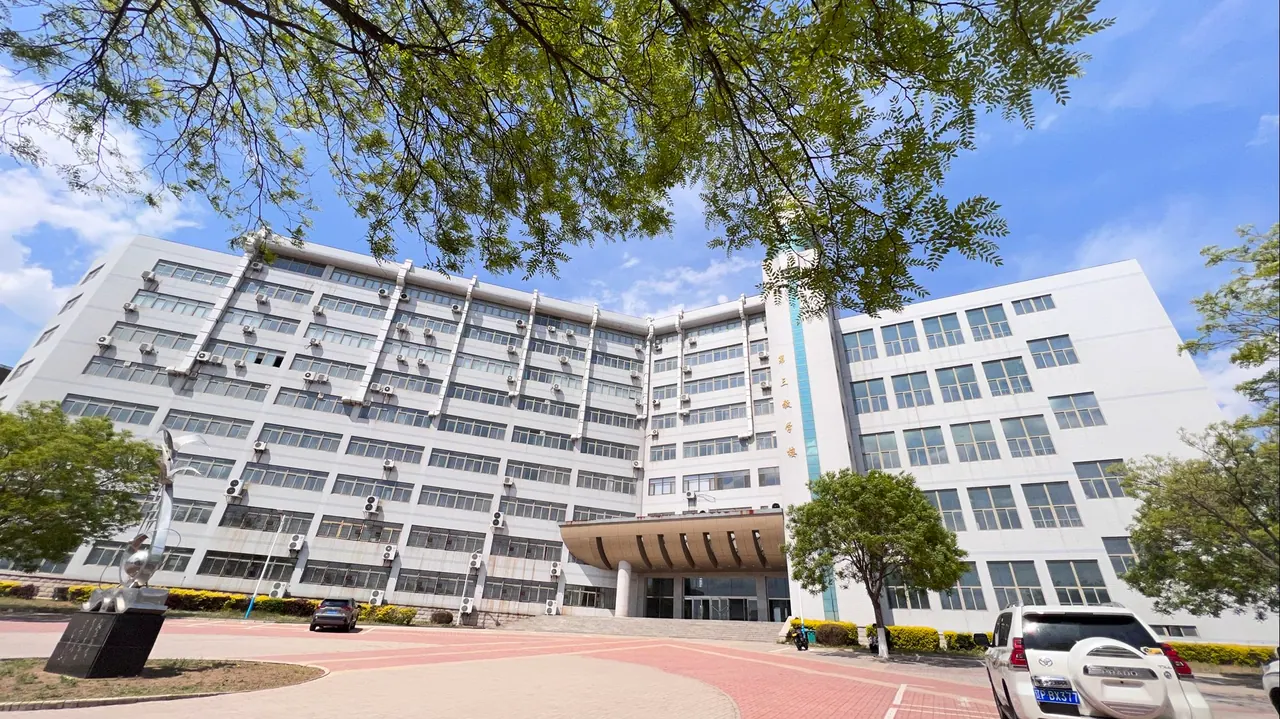 Tòa nhà màu sáng ôm quanh sân lát gạch trong khuôn viên Đại học Y khoa Cẩm Châu.