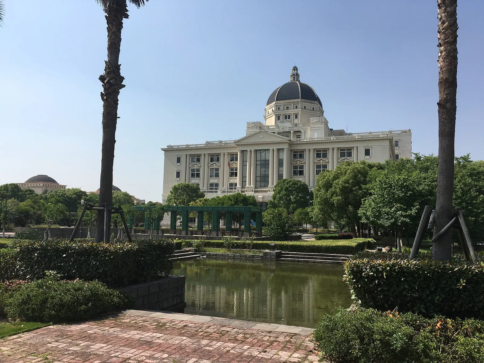 Thư viện mái vòm tại cơ sở Tùng Giang của Đại học Ngoại ngữ Thượng Hải nhìn qua hồ và hàng cọ.