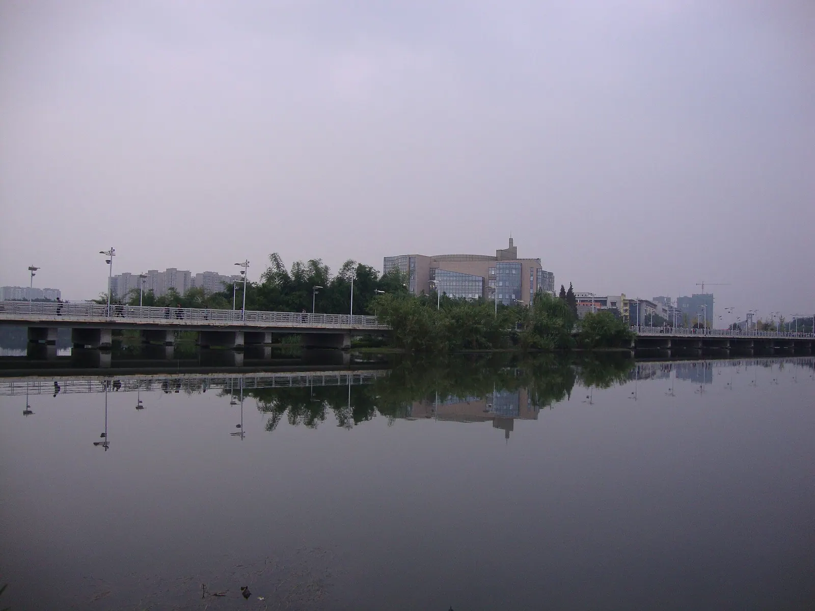 Thư viện Giang An của Đại học Tứ Xuyên phía sau hồ và cây cầu.