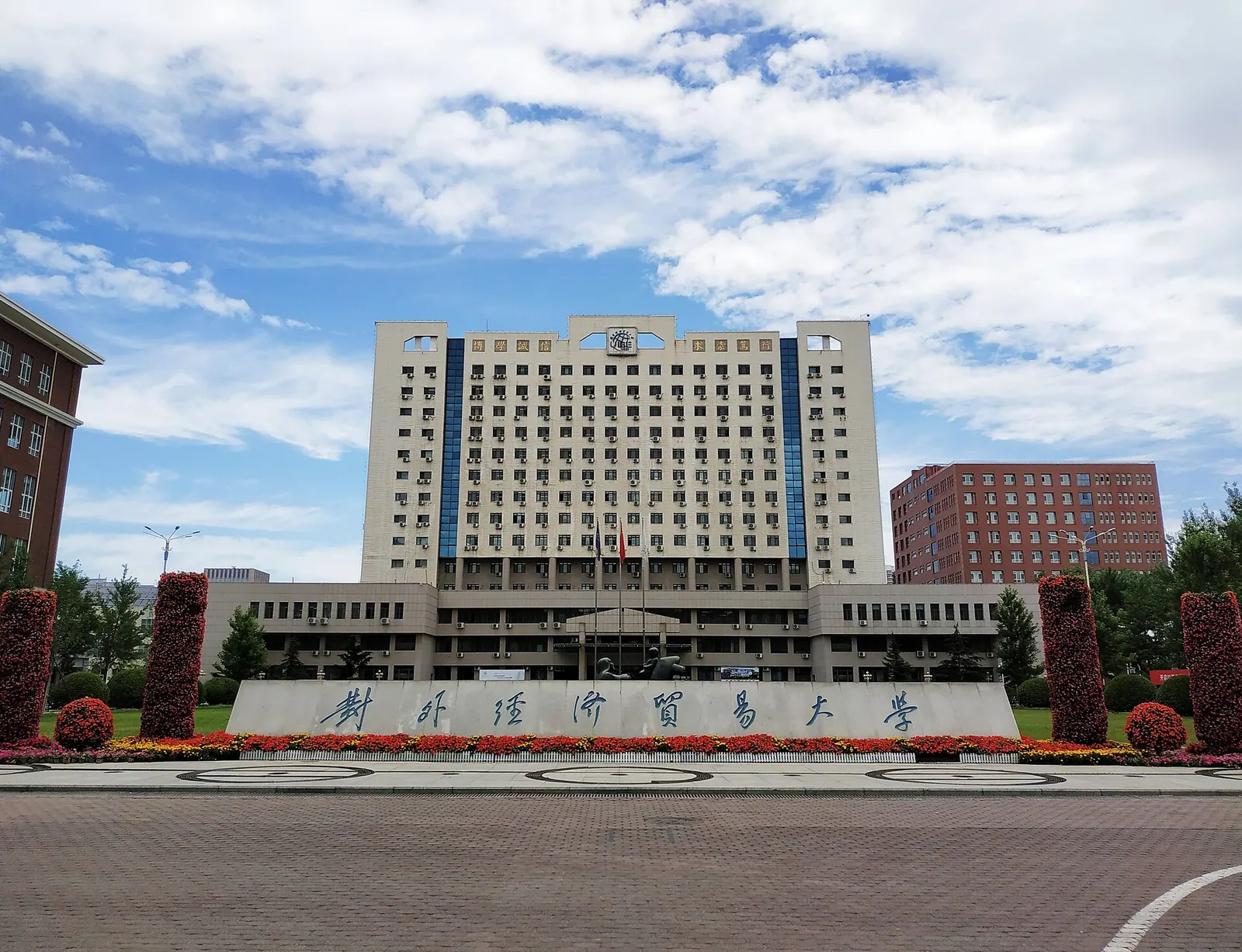 Tòa Chengxin và biển tên Đại học Kinh tế và Thương mại Quốc tế tại Bắc Kinh dưới trời xanh.